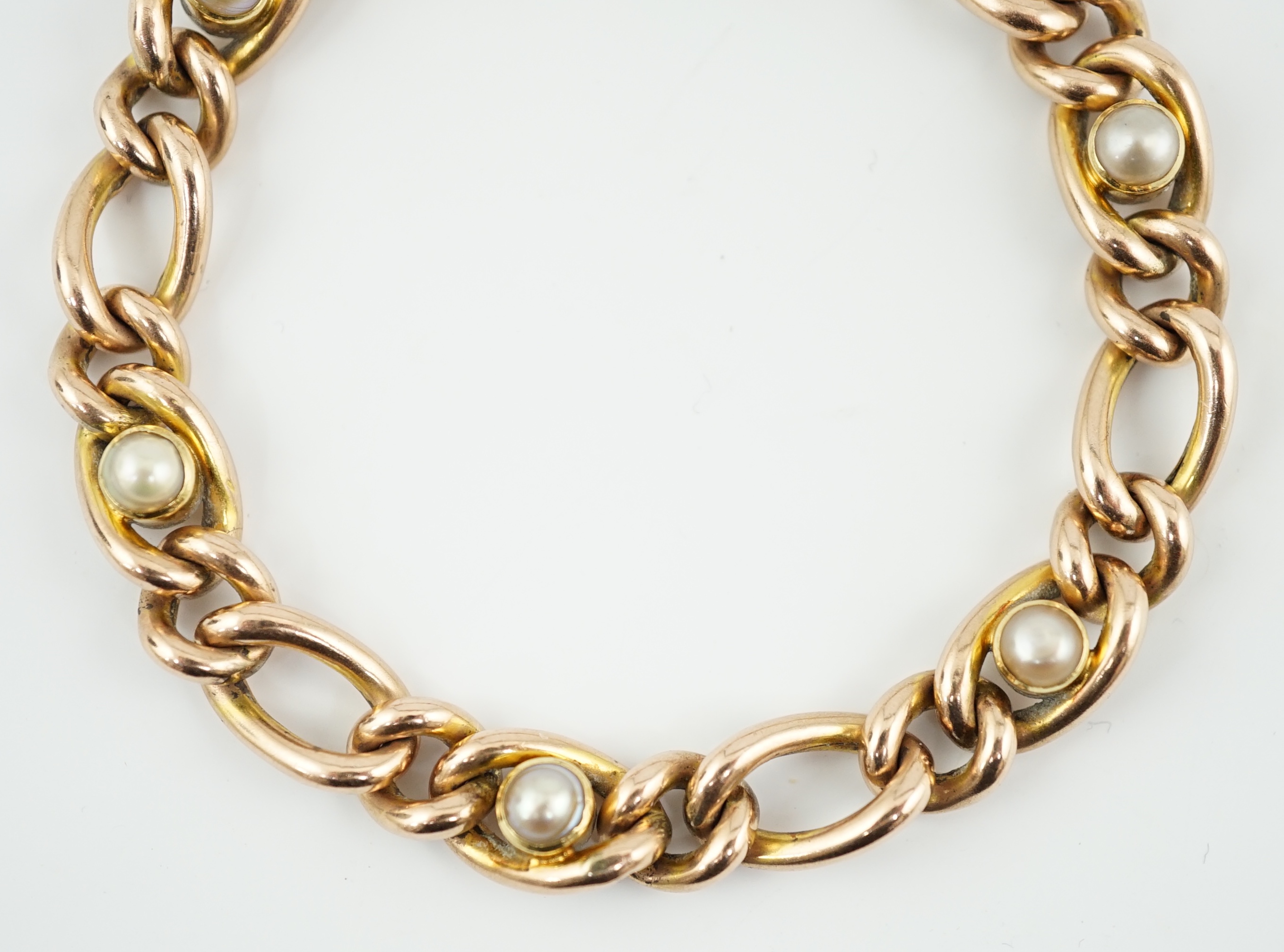 An Edwardian 9ct gold and split pearl set curb link bracelet